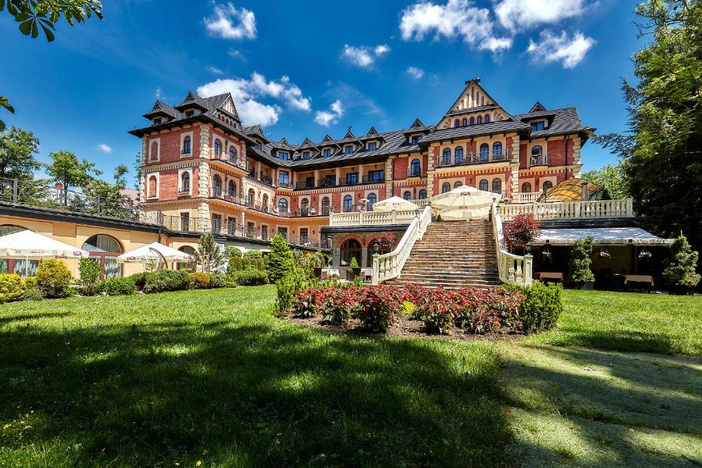 扎科帕内扎科帕大酒店的一座大型红砖建筑,有草地庭院