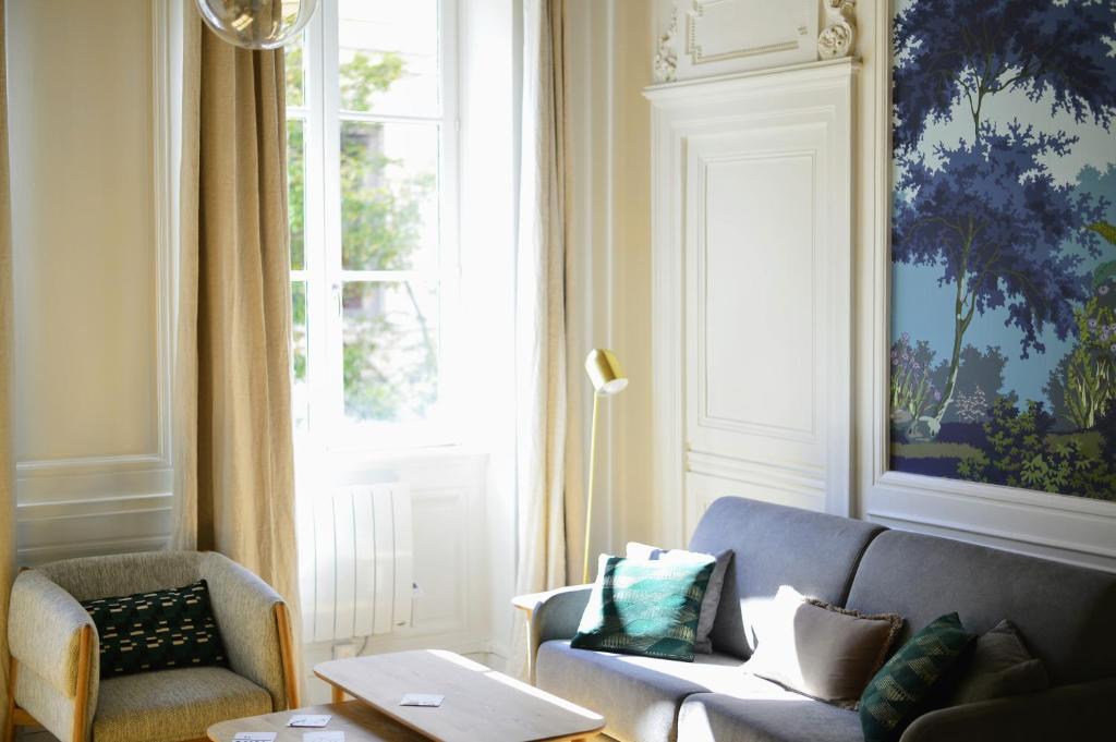 里昂Eden blue, Lovely flat, bright & cosy in Lyon的带沙发和窗户的客厅