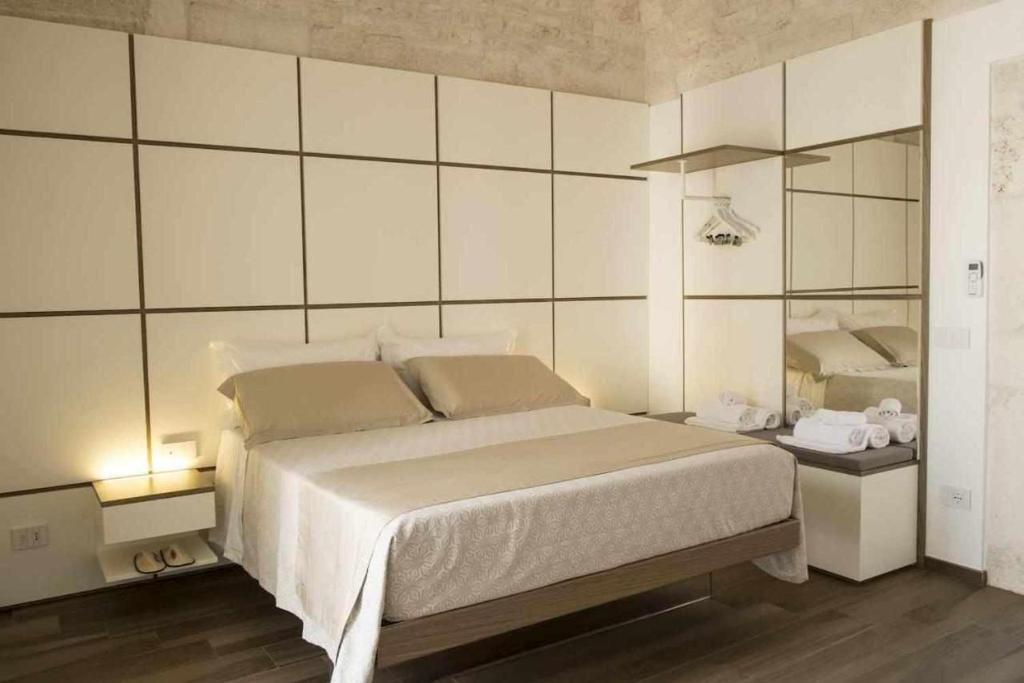 普蒂尼亚诺Ulivi Bianchi Luxury Home in Puglia的卧室配有一张白色大床和镜子