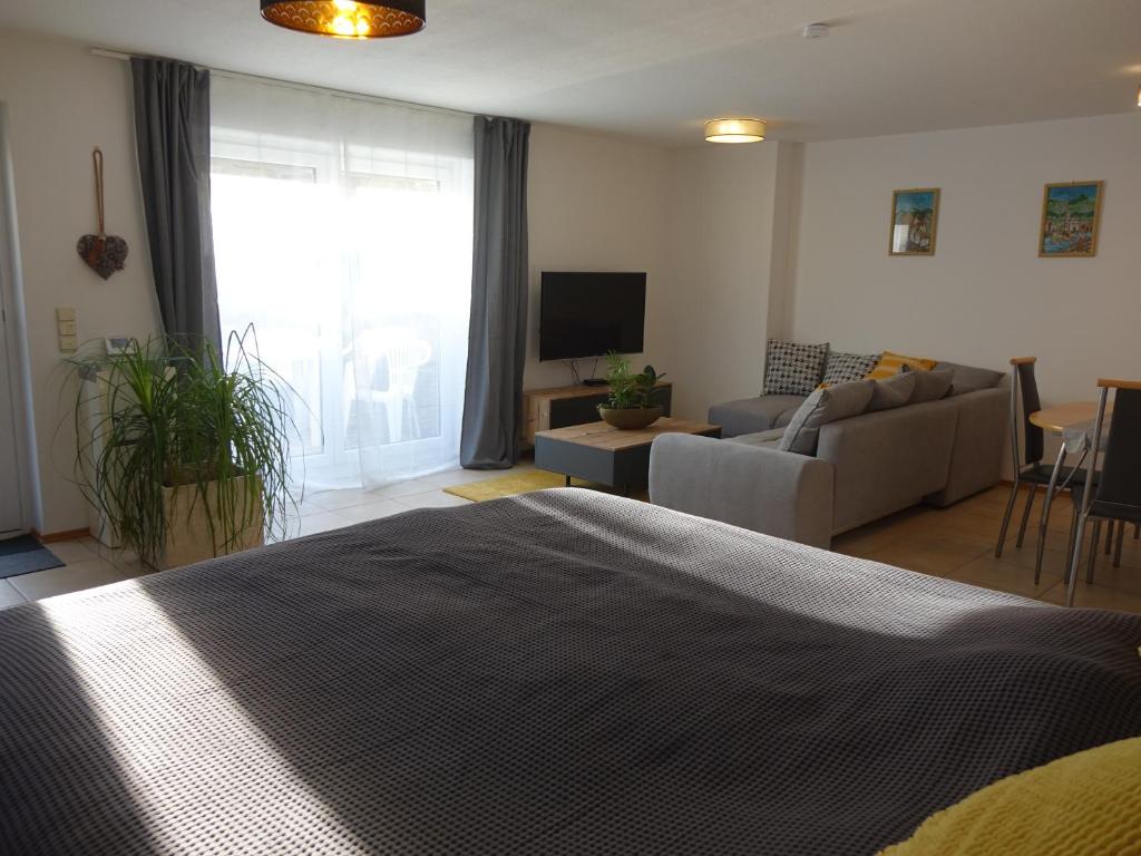 GaukönigshofenExclusive cozy apartment in the heart of Franconia的一间卧室设有一张床和一间客厅。