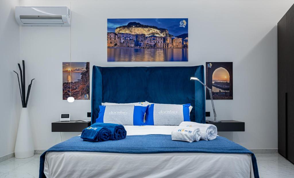 切法卢BM SUITES CEFALU的一间卧室配有蓝色的床和毛巾
