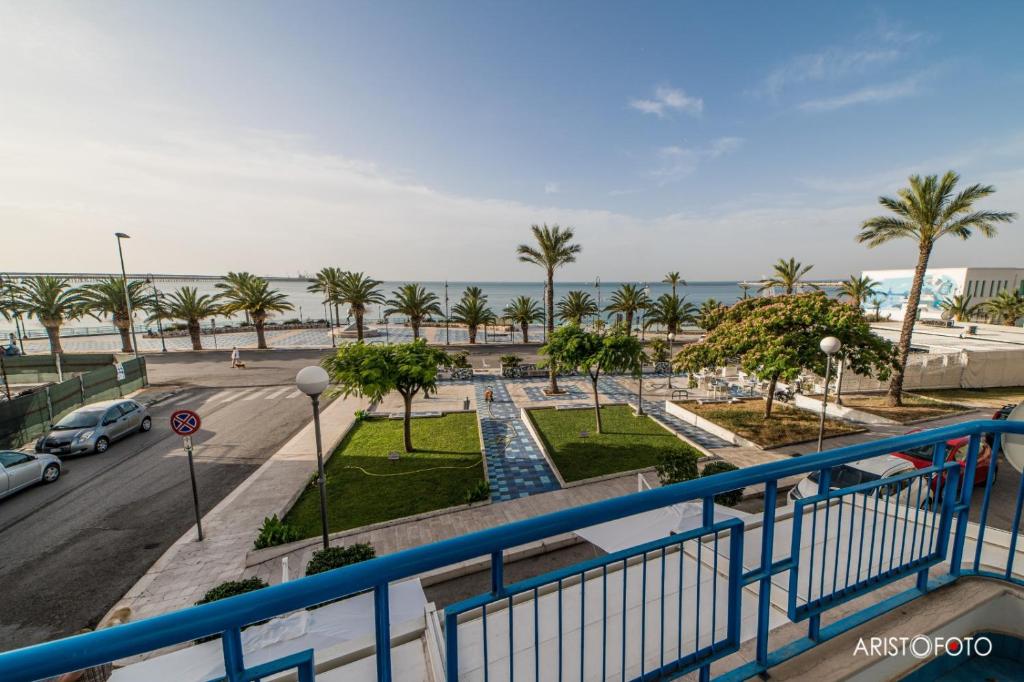 曼弗雷多尼亚B&B Una Rotonda sul mare的阳台享有街道和大海的景致。