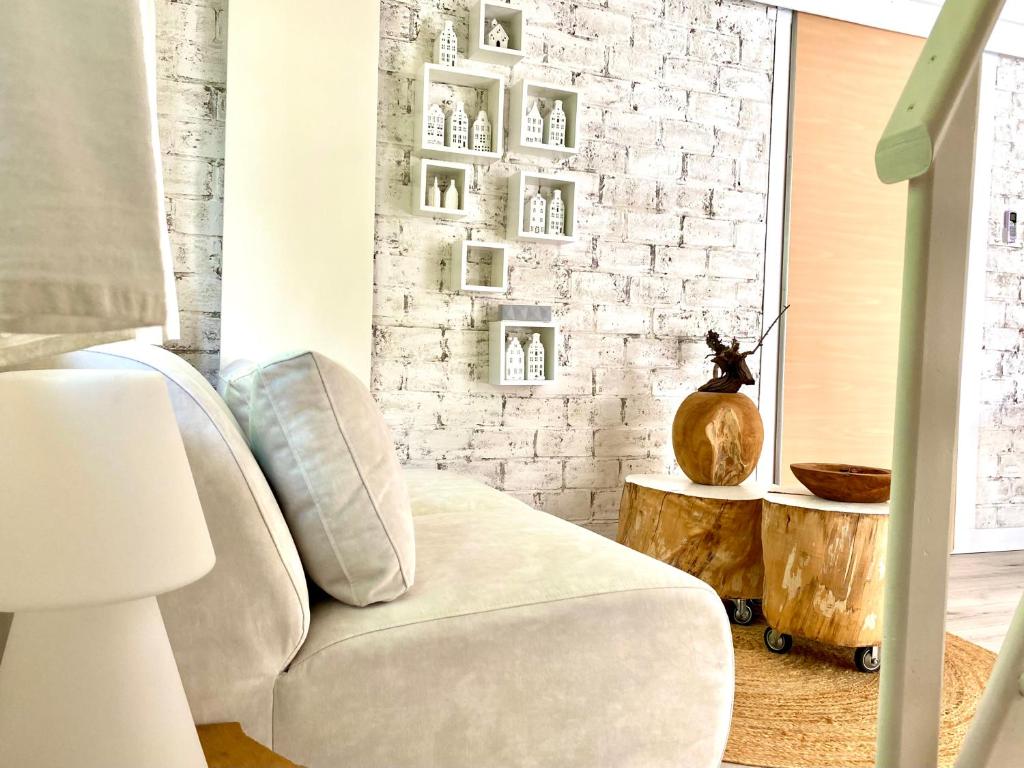 阿尔克马尔Casa De Palmas - Tiny house的客厅配有椅子和砖墙