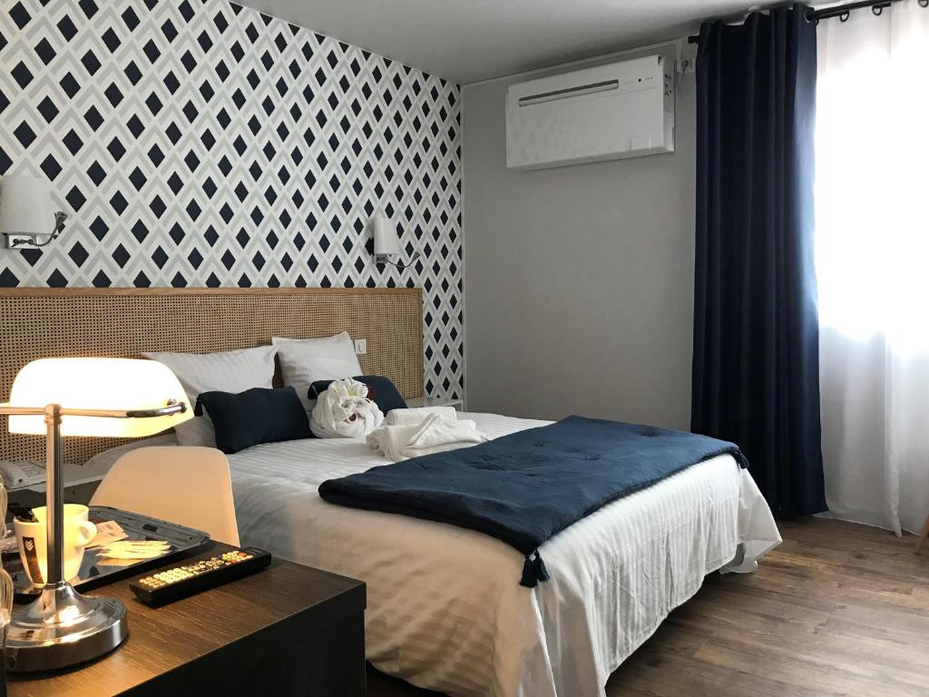 洛特河畔的维伦纽夫冰川酒店的一间卧室配有一张大床和一张桌子