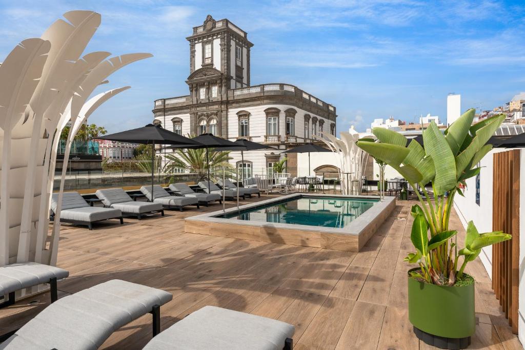 大加那利岛拉斯帕尔马斯Boutique Hotel Cordial La Peregrina的一个带游泳池和大楼的户外庭院