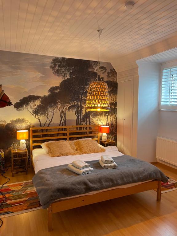 NieuwmunsterZee Vakantievilla Begijnhof 5 De Haan的卧室配有一张大床,墙上挂有绘画作品