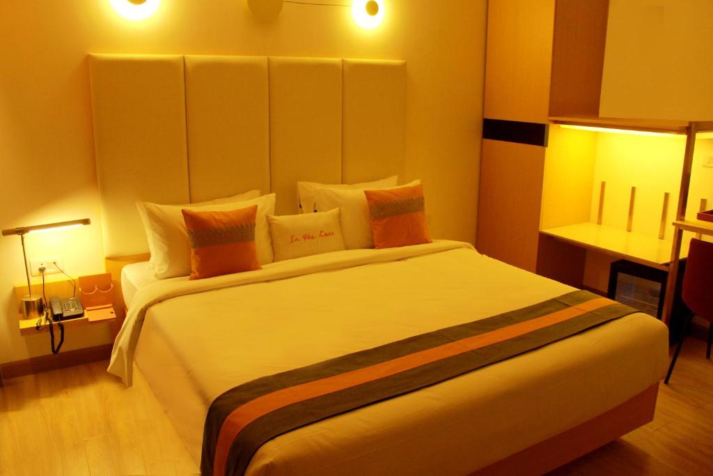 哥印拜陀Zone Connect by The Park Coimbatore的卧室配有带橙色枕头的大型白色床