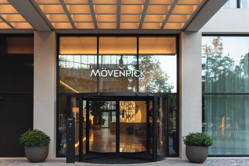 巴塞尔Mövenpick Hotel Basel的带有旋转门的建筑,上面有标志