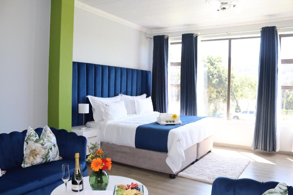 圣约翰港Uzuri Lifestyle的卧室配有蓝色和白色的床和沙发