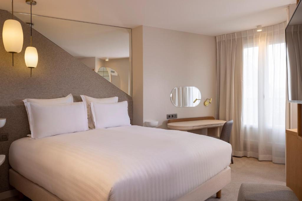 巴黎Hôtel Beige的酒店客房设有一张白色大床和一个窗户。