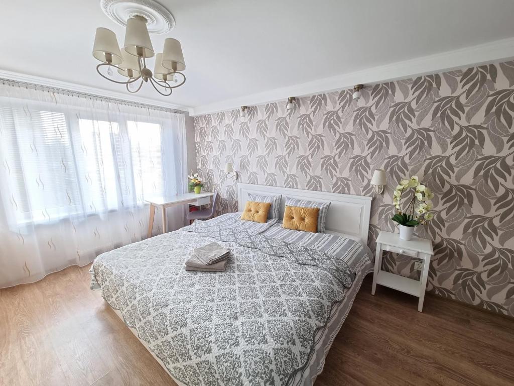 克拉斯拉瓦Kraslava 2 Bedroom Lux Apartments的卧室配有一张带灰色和白色床单的床。