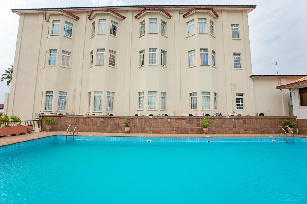 阿克拉国会酒店的一座大型建筑,前面设有一个游泳池