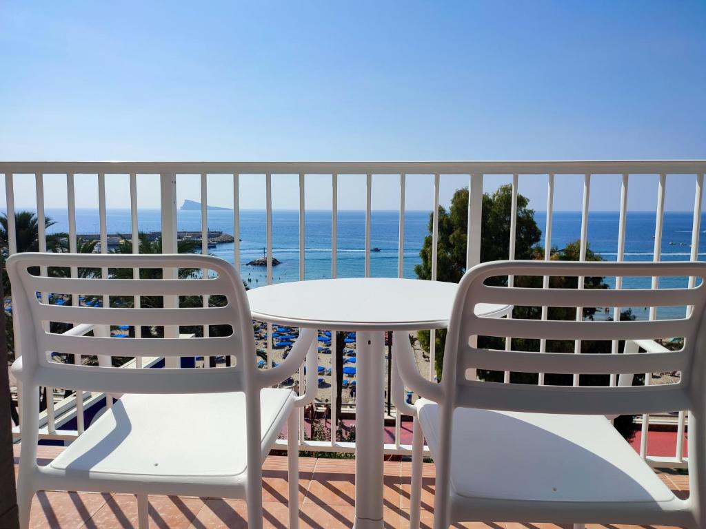 贝尼多姆Hotel Flats Friends Mar Blau的阳台上配有两把椅子和一张桌子,享有海景