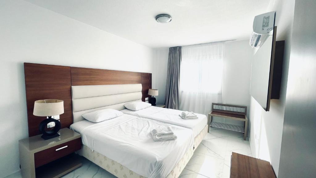 帕拉利米尼Fotoxenia Luxury Apts的酒店客房设有两张床和窗户。