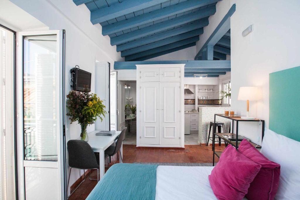 塞维利亚Alojarte Mezquita 5的一间卧室配有一张床铺和一张桌子,还设有一间厨房