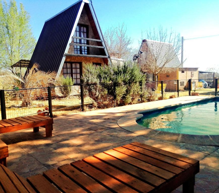 比亚莱特马西Cabañas Alpinas Terra Natura的一个带长凳和房子的游泳池