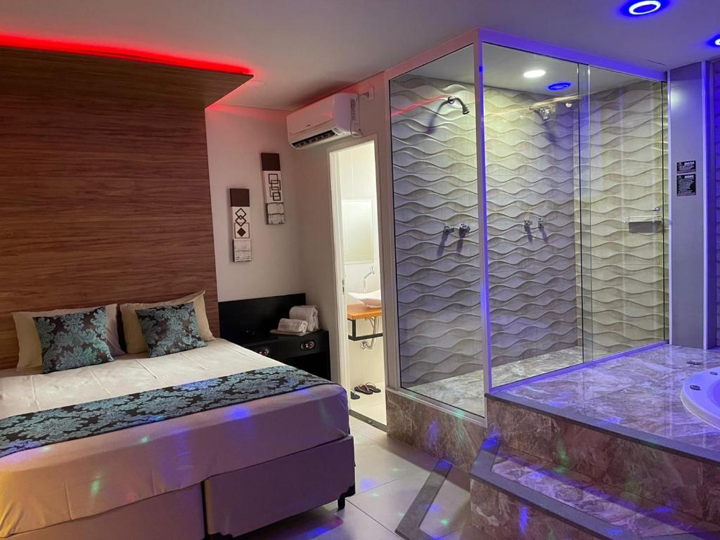 布拉干萨-保利斯塔Green It Motel & Hotel的一间卧室设有淋浴、一张床和一个浴缸。