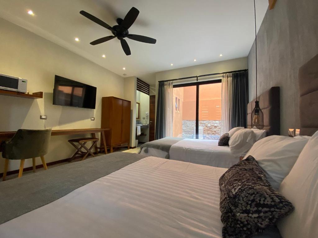 圣路易斯波托西Hotel Arista 1026的酒店客房配有两张床和吊扇。