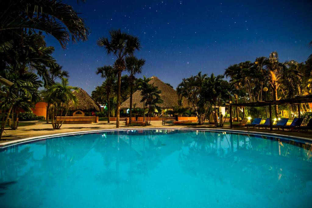 Chulamar太阳城太平洋酒店的夜晚的蓝色泳池,背景是群山