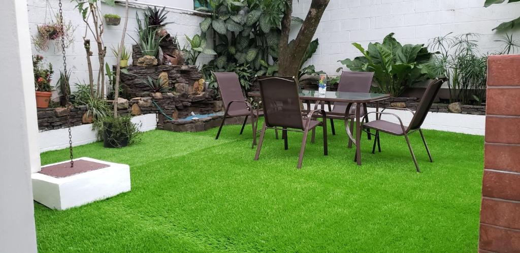 圣萨尔瓦多Green life的一个带绿草和桌椅的庭院