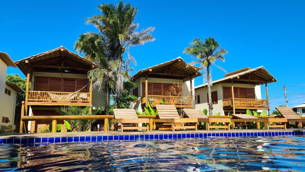 巴拉格兰德Taipu de Fora - Casa Charme的一个带游泳池和椅子及棕榈树的度假村