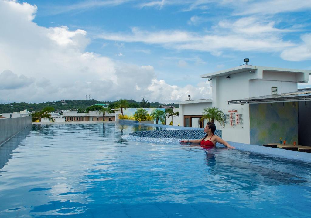 长滩岛长滩岛阿罗哈酒店的坐在建筑物顶部游泳池里的女人