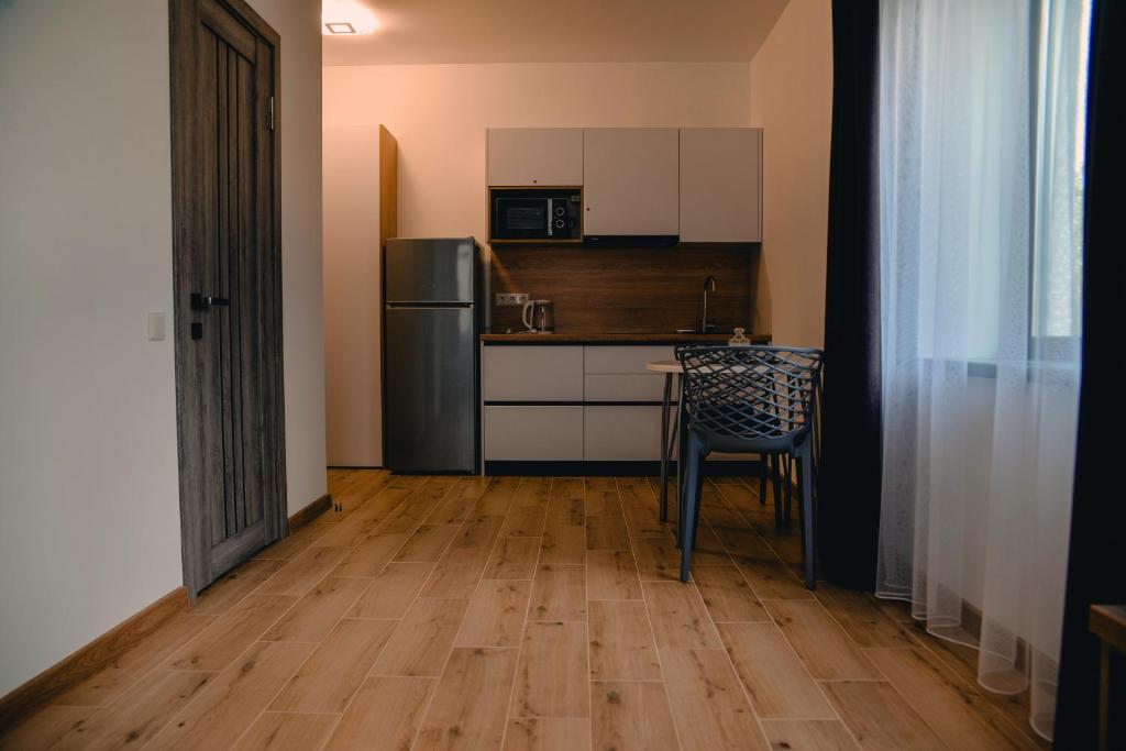 切尔卡瑟Four Rooms Apartments的厨房配有冰箱、桌子和椅子