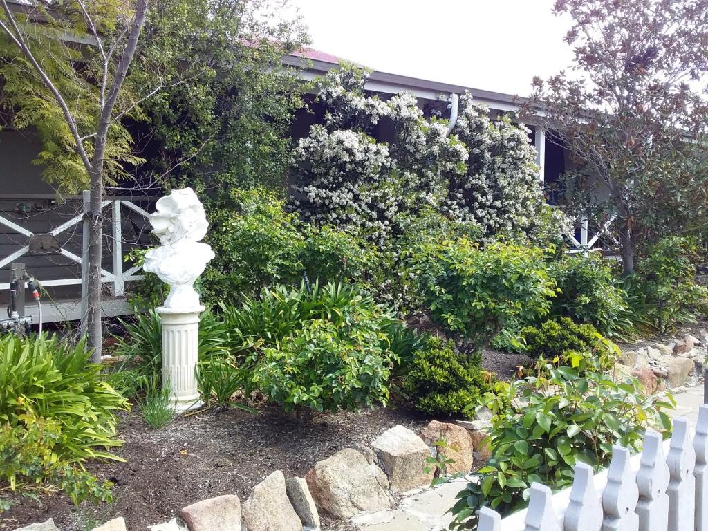 WaginWagin Cottage Garden Bed and Breakfast的白色栅栏旁花园中的白色雕像