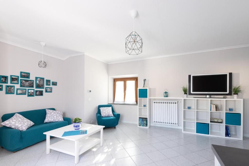 尼阿博勒皮耶韦Tuscany To Love - Holiday Home - Casa Vacanze的客厅配有蓝色的沙发和电视