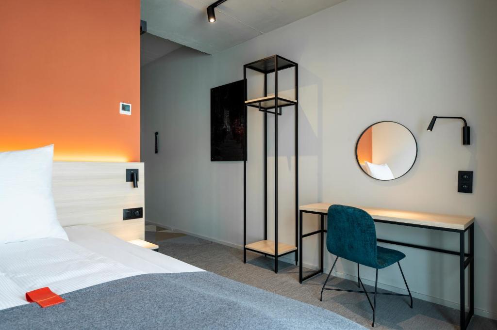 安特卫普Citybox Antwerp的一间卧室配有一张床、一张书桌和一面镜子