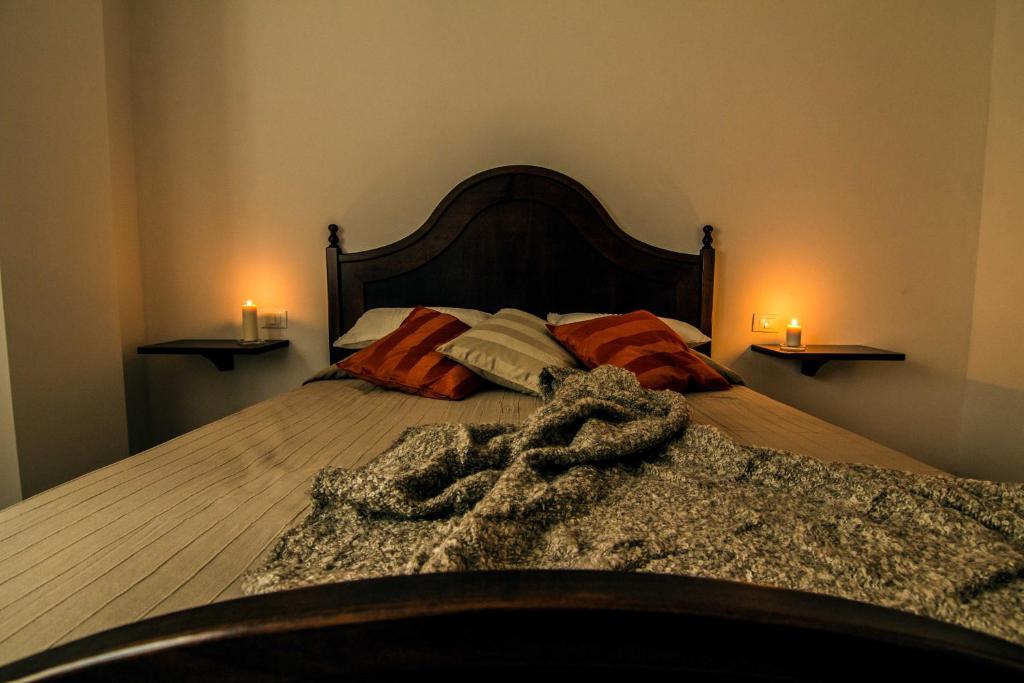 罗卡迪坎比奥Campo Felice Experience的卧室配有一张床铺,墙上挂有两根蜡烛