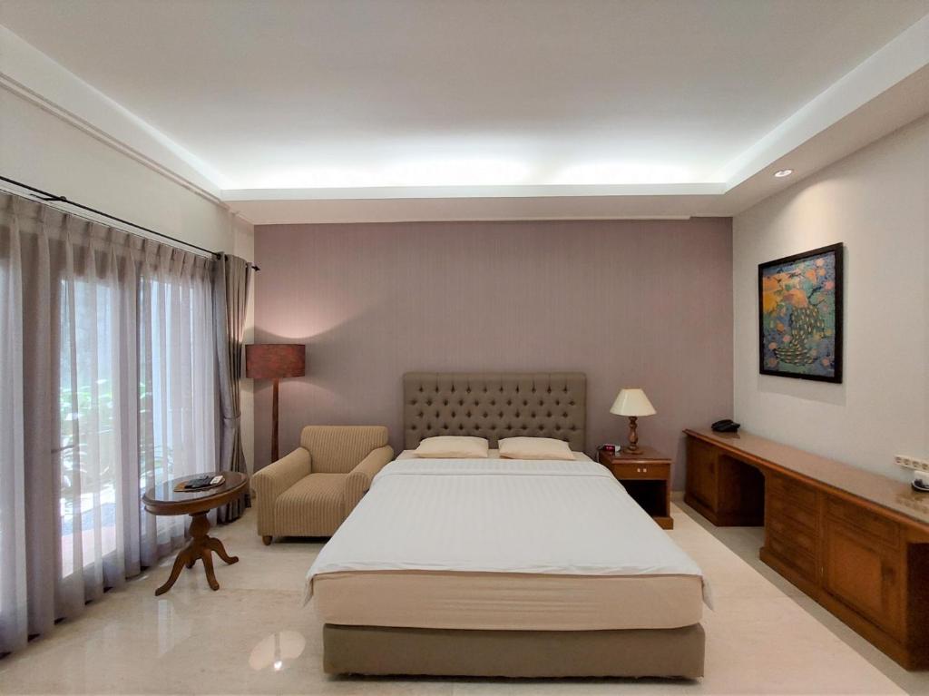 雅加达Via Renata Prapanca的卧室配有床、椅子和窗户。