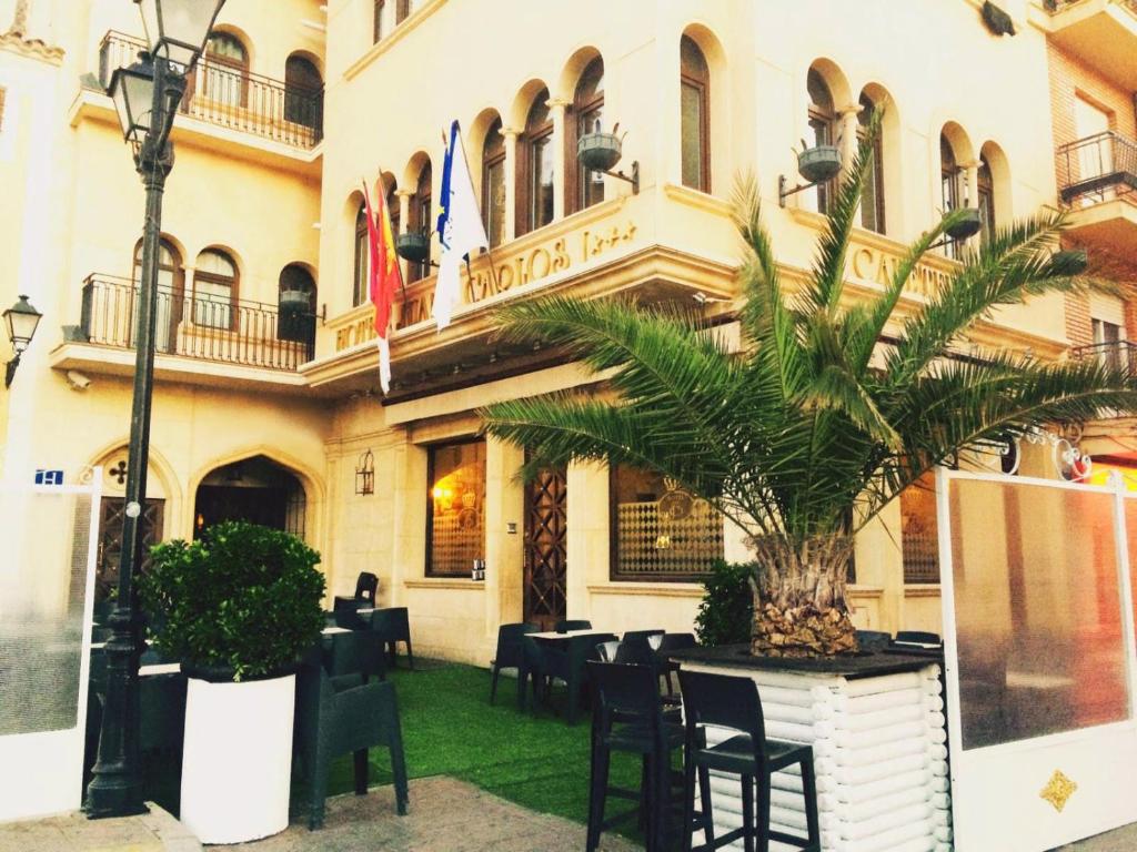 比利亚罗夫莱多胡安卡洛斯一世酒店的一座楼前有棕榈树的餐厅