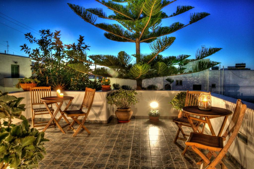 纳乌萨安娜膳食公寓旅馆的一个带2张桌子和椅子的庭院和棕榈树