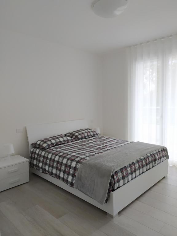 利多迪耶索罗Jesolo Appartamenti F2 - Light Blue的一间白色卧室,配有床和床头柜