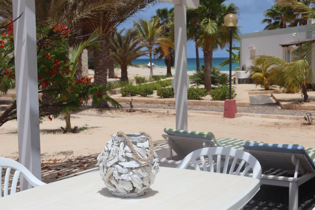 RabilSea view sol & mar的海滩上一张桌子和花瓶