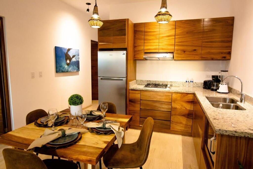 拉巴斯Ancla Baja Living Condominio nuevo con vista 4的一间带木桌和椅子的厨房以及一间配有冰箱的厨房