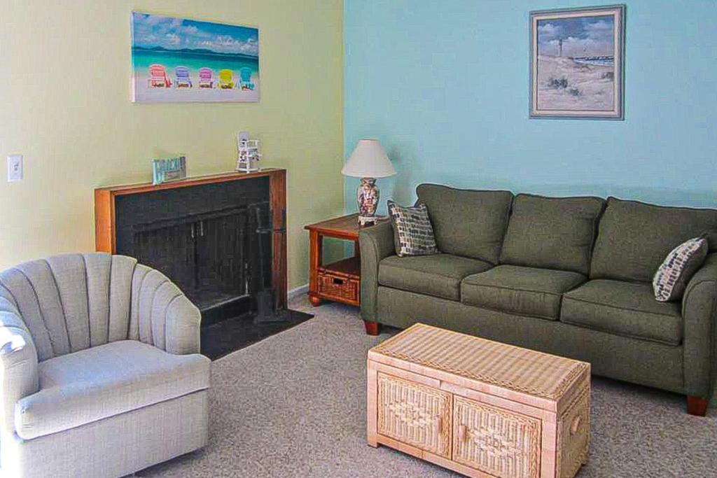 贝瑟尼滩Villas of Bethany West -- 722C Treetop的带沙发、椅子和壁炉的客厅