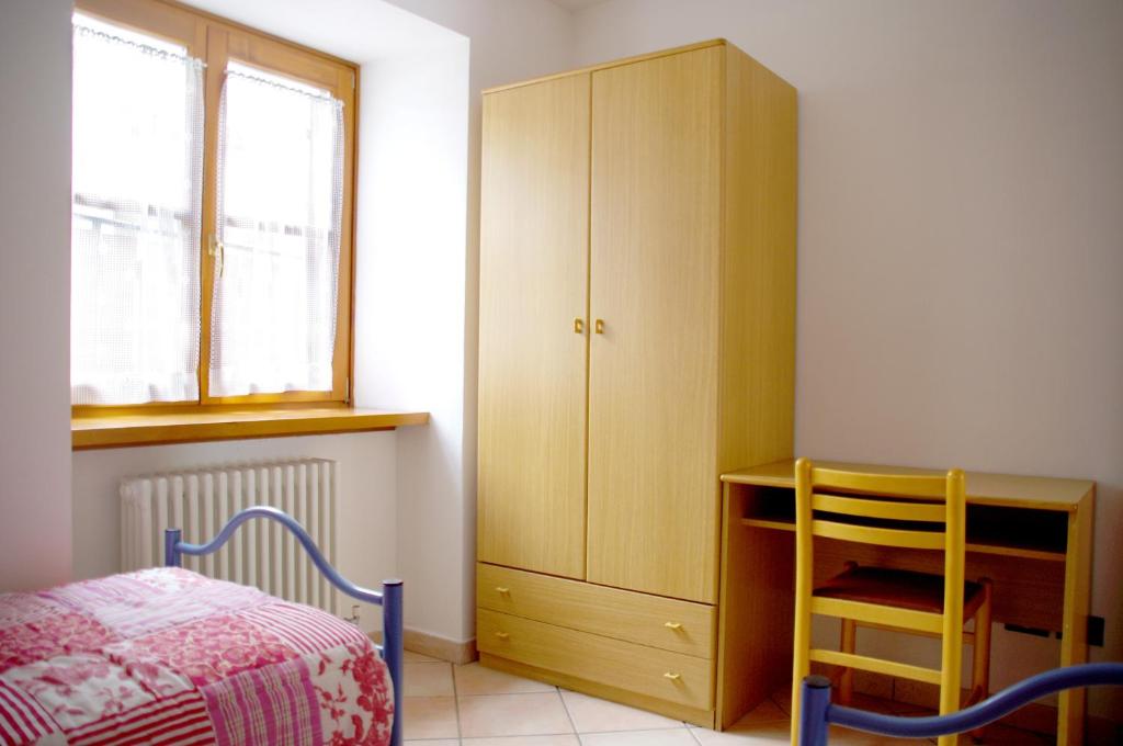 莫尔韦诺Appartamenti -Casa Nicolussi-的一间卧室配有一张床、一张书桌和一个橱柜