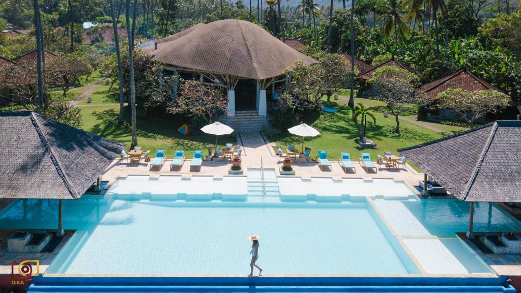 甘地达萨莲花简易别墅酒店的站在度假村游泳池中的女人