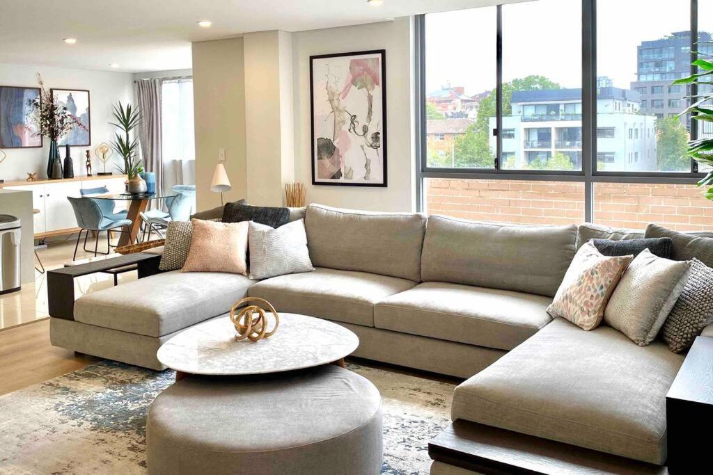 悉尼Crows Nest - Executive Penthouse - 3 Bedroom- 5km to City的客厅配有沙发和桌子