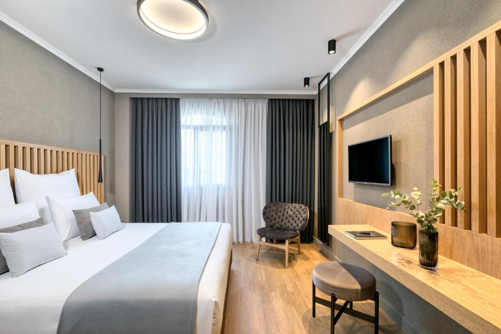塞萨洛尼基Porto Palace Hotel Thessaloniki的酒店客房设有一张大床和一张书桌。