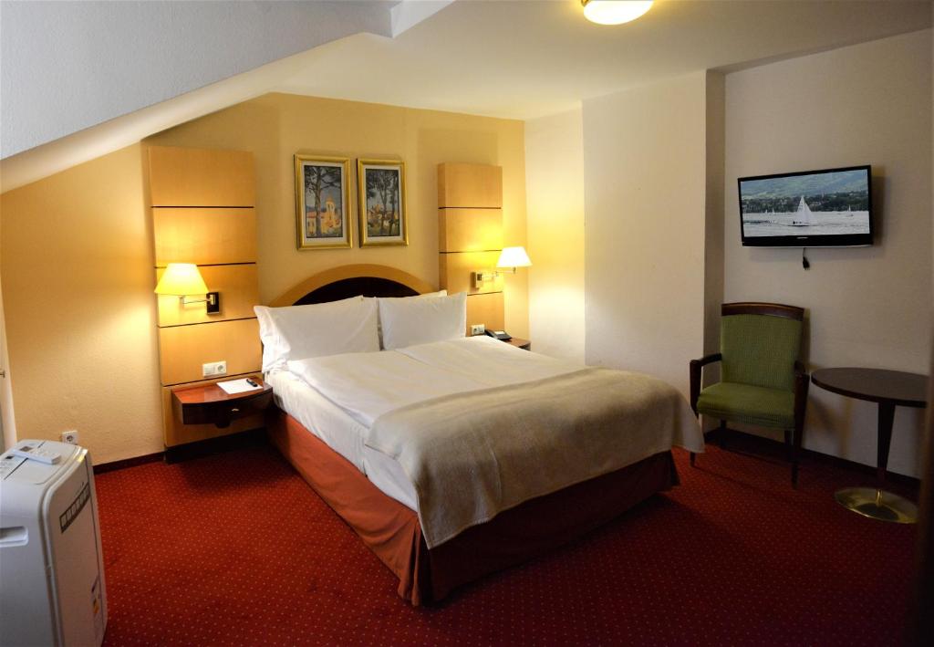 威斯巴登埃姆考奇博恩酒店的酒店客房设有一张大床和一张绿色椅子。