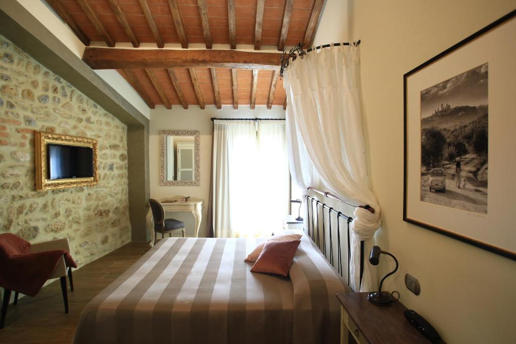 圣吉米纳诺莫里诺蒂费茨酒店的一间卧室配有一张床、一个窗口和一张书桌
