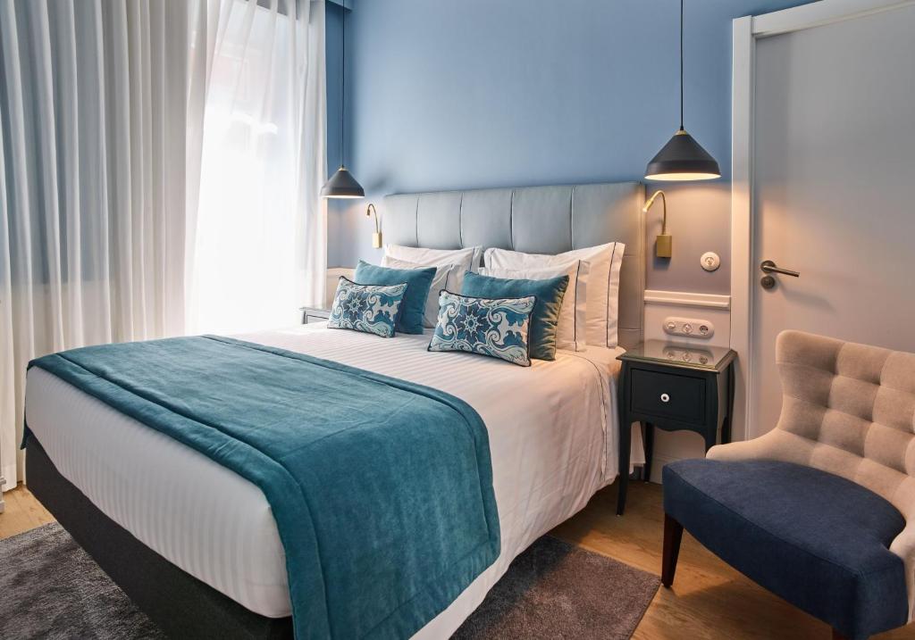 里斯本弗兰斯特住宿酒店的一间卧室配有一张大床和一把椅子