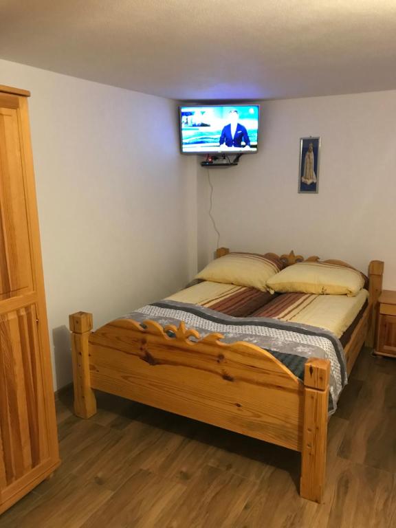斯罗姆韦斯尼Apartament i pokoje u Piotra的卧室配有一张床铺,墙上配有电视