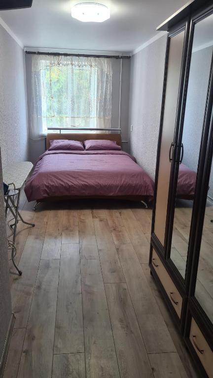 米尔哥罗德2-х кімнатна квартира студія у центрі Миргорода的一间卧室设有一张床、一个窗口和一面镜子