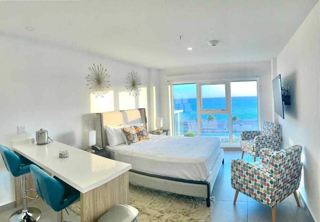 奥拉涅斯塔德Ocean View Condo overlooking the Caribbean Sea的卧室配有一张床、一张桌子和椅子