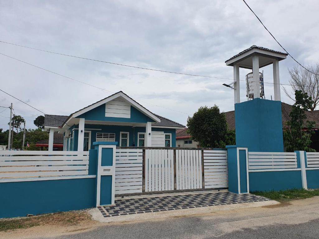 哥打巴鲁Casa De Rose KUBANG KERIAN的蓝色的房子,有白色的栅栏和门