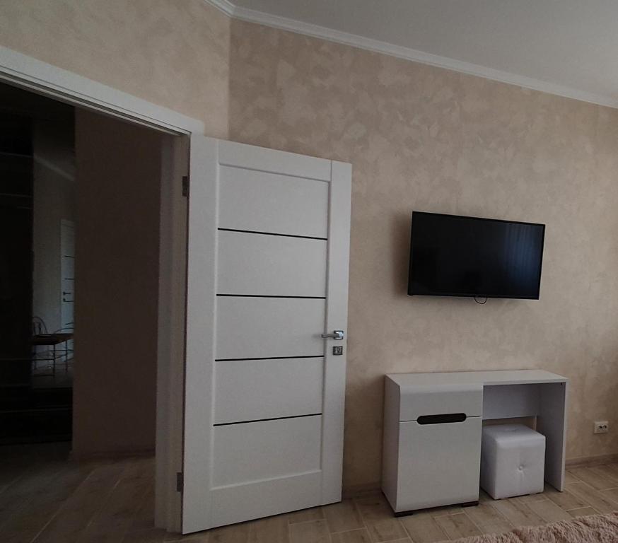 Chortkivапартаменти квартира的一间设有门的房间和墙上的电视